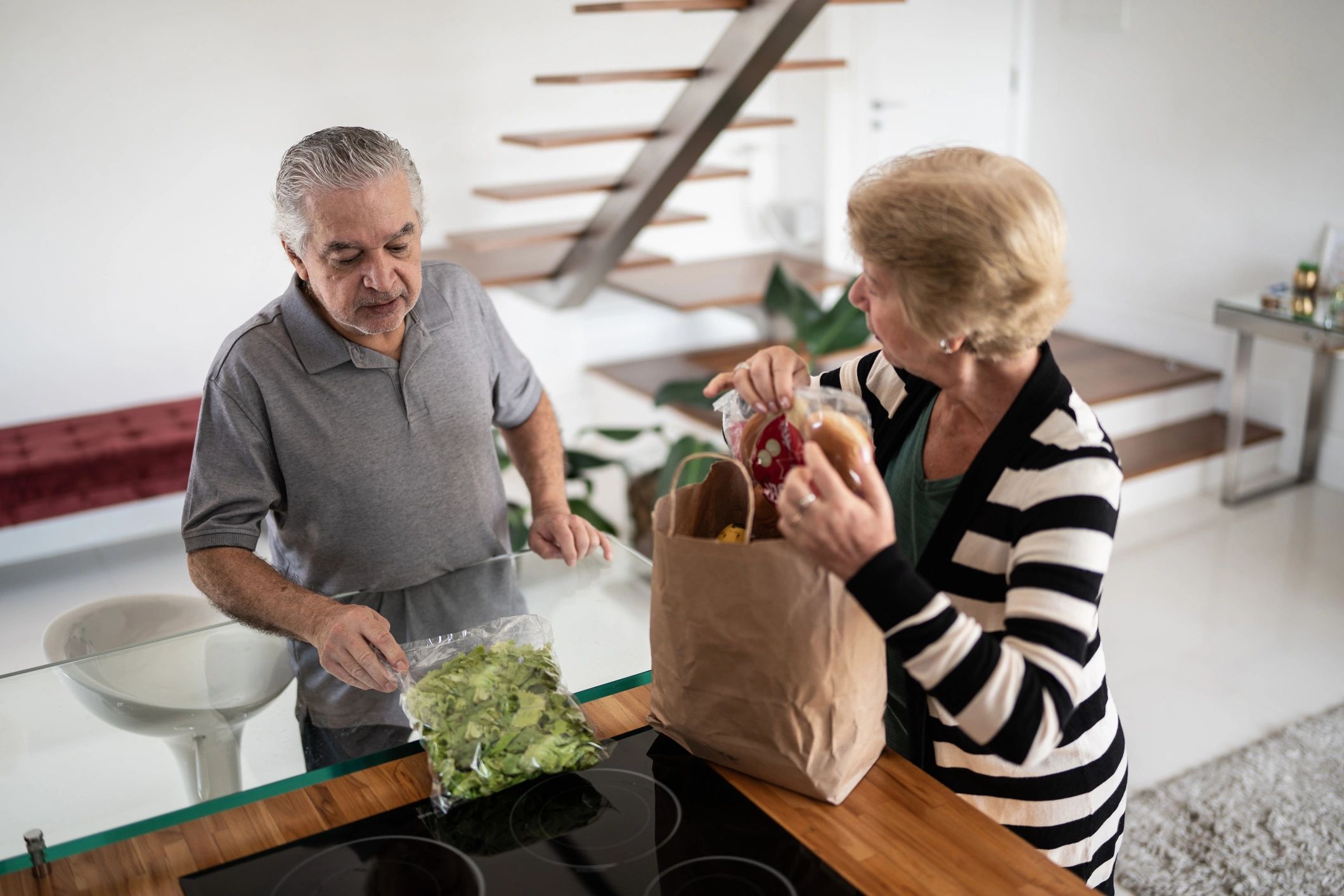 Senior couple unpacking groceries at home