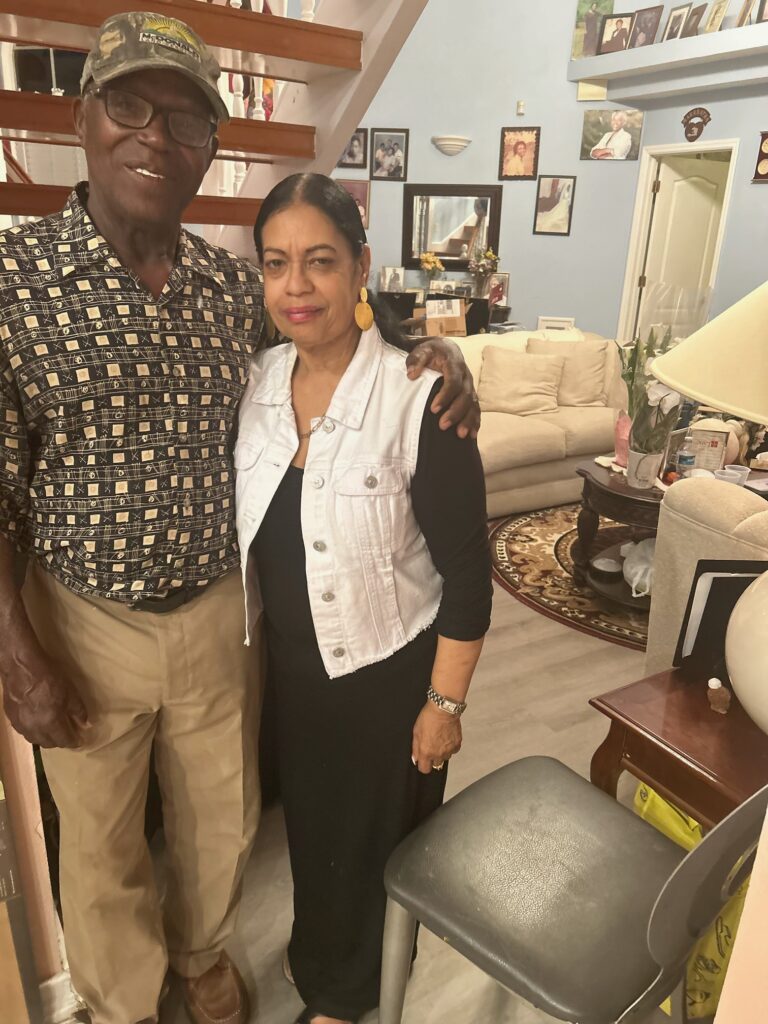 Smiling couple posing in a living room.